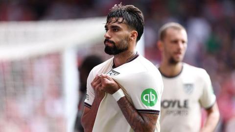 Lucas Paqueta holding the West Ham badge on his shirt