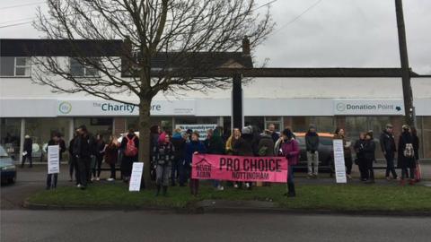 People gather outside charity shop