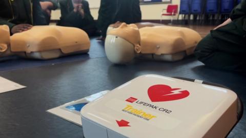 A defibrillator training pack and training dummies