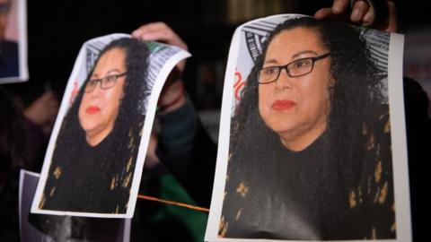 A man holds photos of journalist Lourdes Maldonado Lopez during a protest to demand justice, in front of the Interior Ministry Office, in Mexico City, Mexico on 25 January