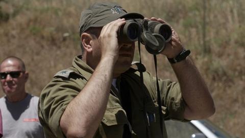 Israeli army officer using binoculars on the occupied Golan Heights