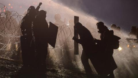 Protesters tried to shield themselves from the police water cannons.