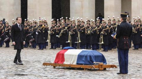 French President Emmanuel Macron walks towards the coffin Lt Col Arnaud Beltrame