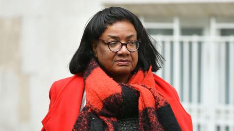 Diane Abbott wearing a red coat