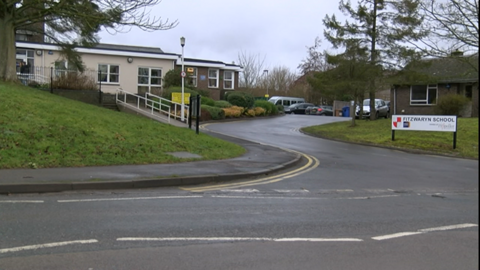 A collection of buildings with a sign in the foreground saying 'Fitzwaryn School'.