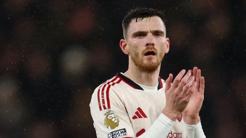 Liverpool left-back Andy Robertson applauds the fans