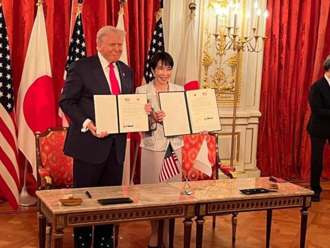 Donald Trump and Sanae Takaichi smile as they hold up the agreements they signed