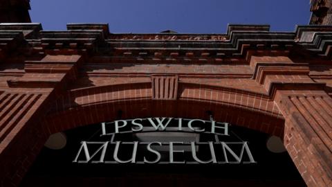 exterior and sign of Ipswich Museum showing red brick Victorian building and lettering