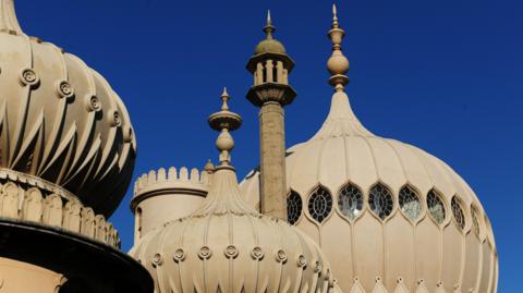 The towers of Brighton Dome against a dark blue sky.