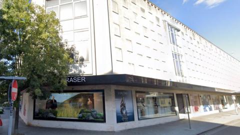 The former House of Fraser building in Camberley, with clear blue skies above.