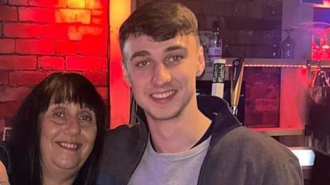 Jay Slater poses with his arm around his mother Debbie Duncan's shoulder. Both are smiling for the camera.