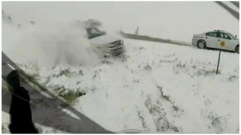 A man seems oblivious as truck careens off a motorway and plummets towards him down a snowy verge.