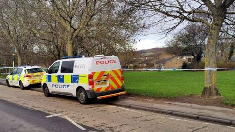 Police vehicles and a cordon at the park