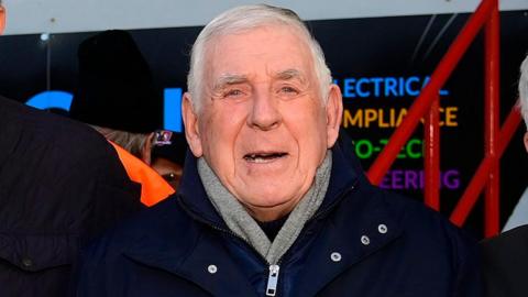Alan Banks wearing a dark coat and a grey scarf