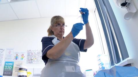 A nurse prepares a botox injection for migraine treatment