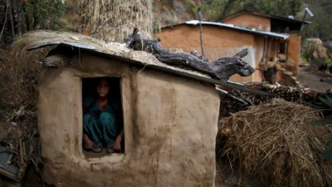 A girl sits inside a Chhaupadi shed