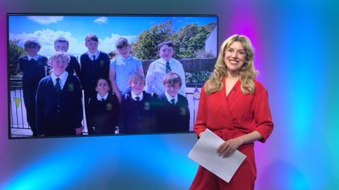 Jenny in the studio with school children in the screen