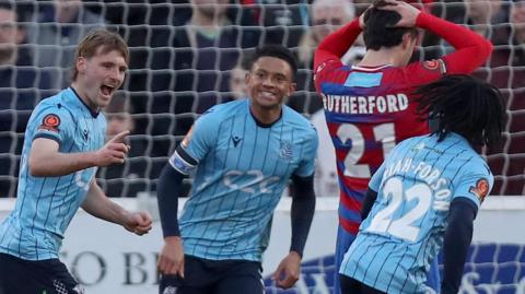 Gus Scott-Morriss (left) celebrates a goal against Dagenham & Redbridge in January