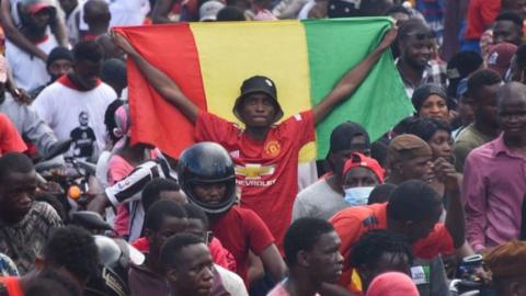 A supporter holds up a Guinean National Flag
