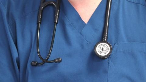 Close-up of doctor's blue tunic with a stethoscope