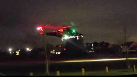 An air ambulance taking off from a field.