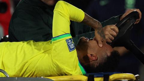 Neymar holds his head after being taken off injured during Brazil's loss to Uruguay