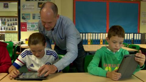 Jeffrey Dodds works with Jolene and Matthew in the classroom