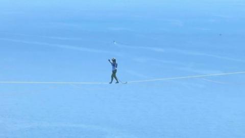 Jaan Roose walking a slackline high above water 