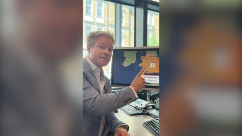 Simon King pointing at a computer screen