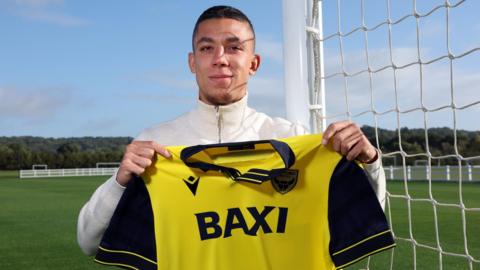 Filip Krastev stands with his Oxford United shirt after signing for the club