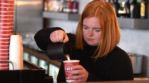 A barista makes a coffee.