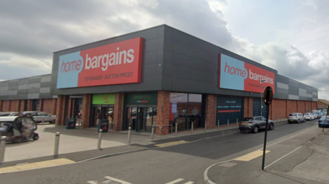 The exterior of a Home Bargains store next to a road.