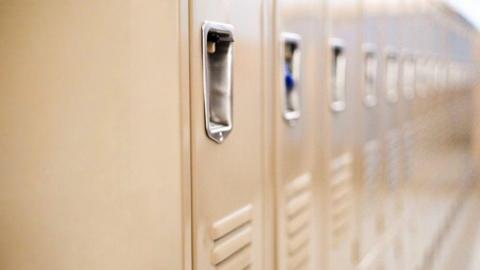 A beige-coloured series of lockers with silver handles. 