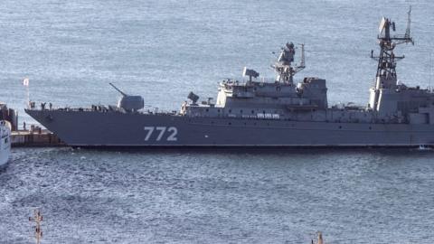 The Russian Neustrashimy frigate - a long, grey vessel with the number 772 printed on the side in white - in the water.