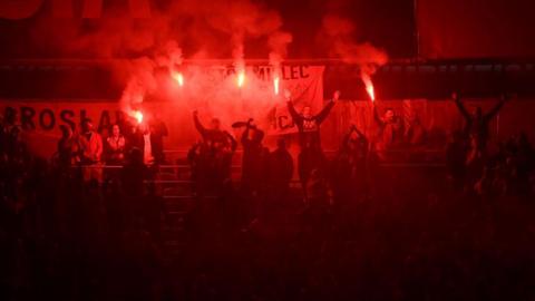 Poland fans holding flares at the Cardiff City Stadium in September 2022 