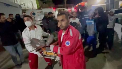 Two paramedics push a trolley holding the body of a World Central Kitchen aid worker