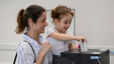 A voter is helped by her three year old daughter to cast a ballot for the European Elections in Escola Básica Parque das Nações on June 09, 2024 in Lisbon