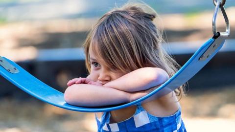 Girl leaning on a swing