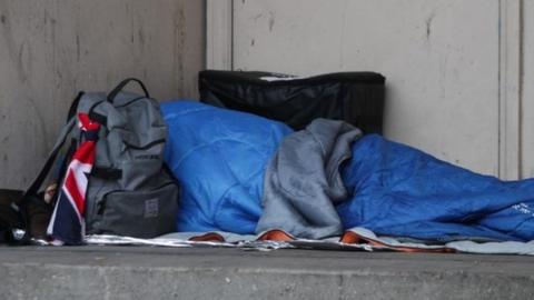 Homeless person sleeping rough in a doorway