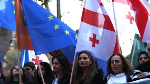 Thousands of people, waving European Union (EU) and Georgian flags take part in an opposition rally on 20 Oct