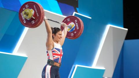 Bella can be see holding lifting weights above her head as she competed at European Weightlifting Championships