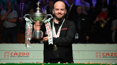 Luca Brecel holding the World Snooker Championship trophy