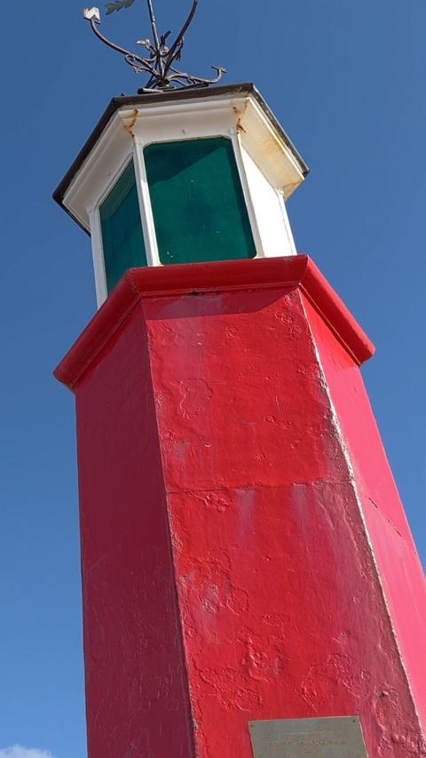 Red lighthouse with white top with glass panels