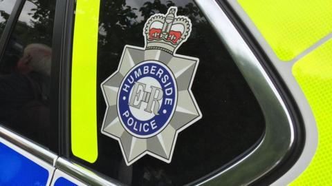 A Humberside police logo on the window of a police car.