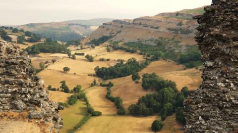 A hilly rural scene with brown fields