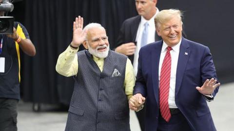 US President Donald Trump and Indian Prime Minister Narendra Modi hold hands as they enter the stadium in Houston to attend 'Howdy, Modi!' in September 22, 2019