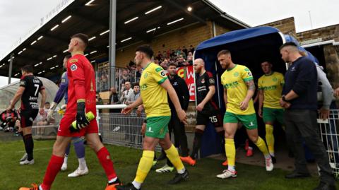 Caernarfon players enter the pitch in Bangor