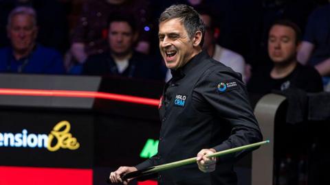 Ronnie O'Sullivan grimaces while holding his cue