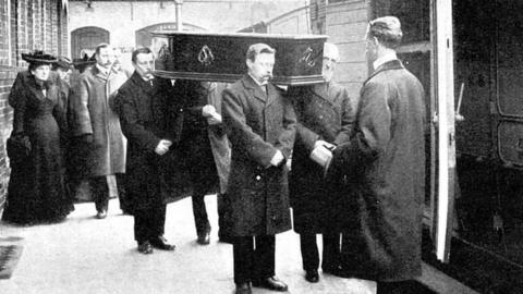 coffins being loaded