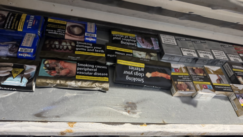 A variety of different packs of cigarettes on a shelf